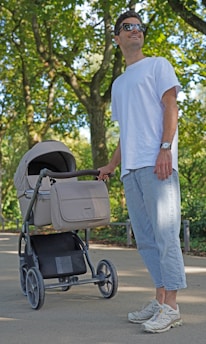 A happy parent assembling a sturdy baby stroller outdoors.