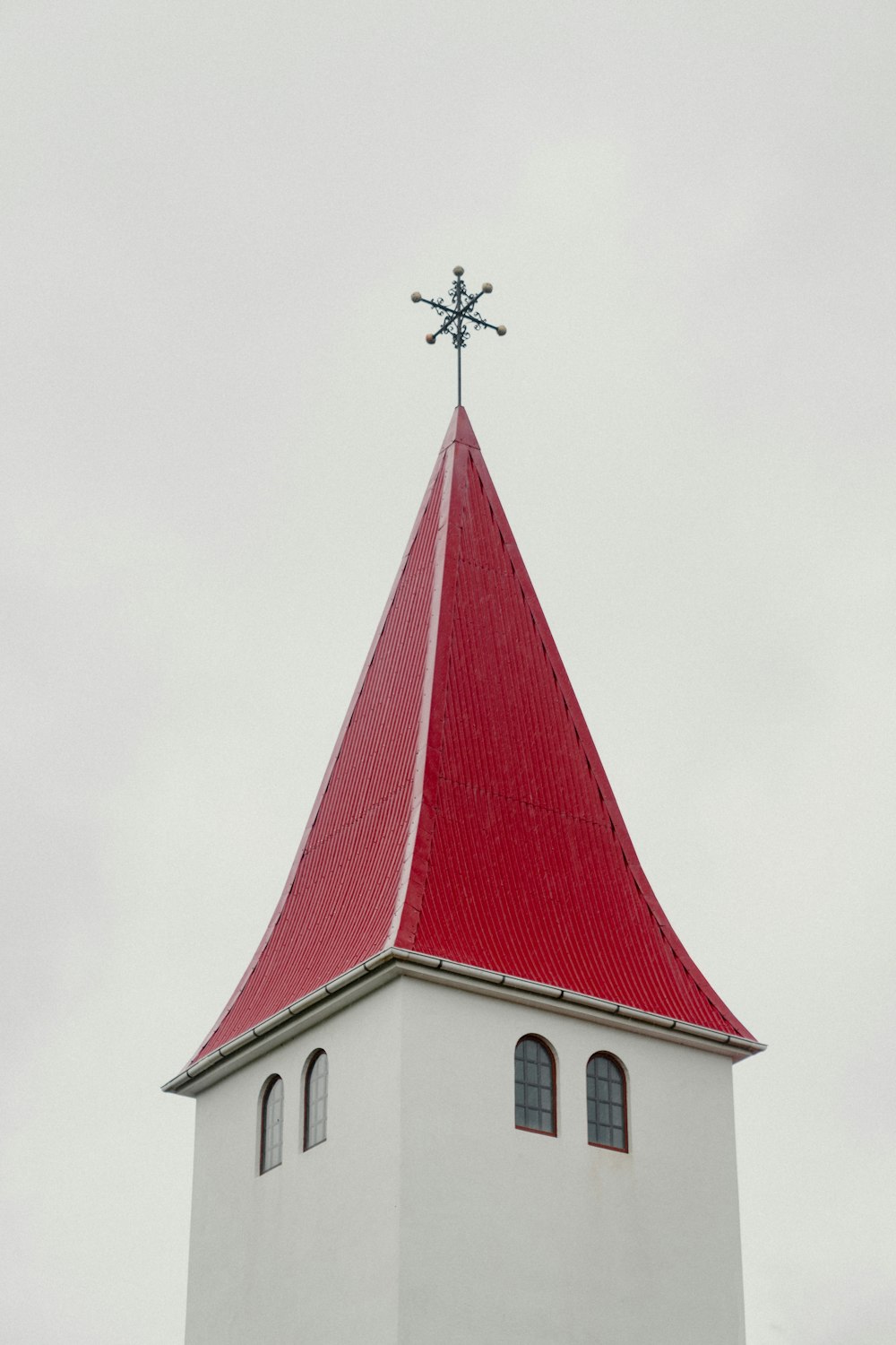 une église blanche avec un toit rouge et une croix sur le dessus