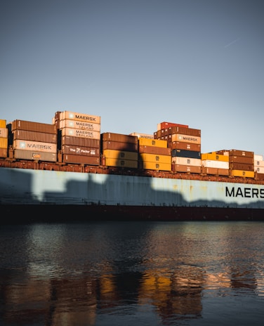 Photo of a cargo ship loaded with containers at sunset, symbolizing international shipping.