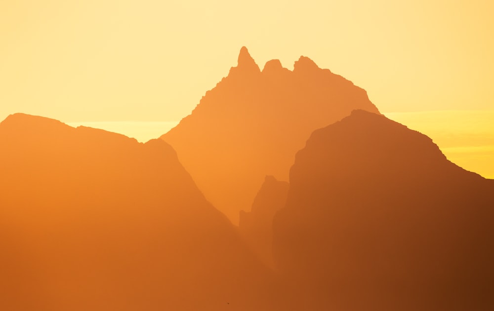 the sun is setting behind a mountain range