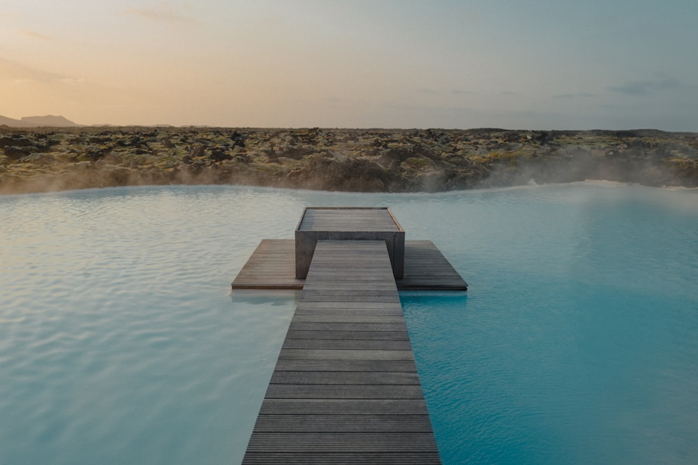 a wooden dock leading to a blue lagoon