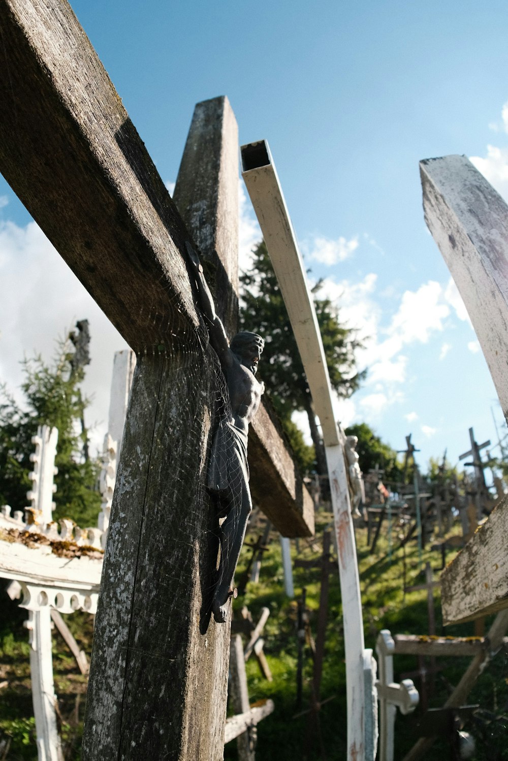 a person climbing up a wooden cross on a sunny day