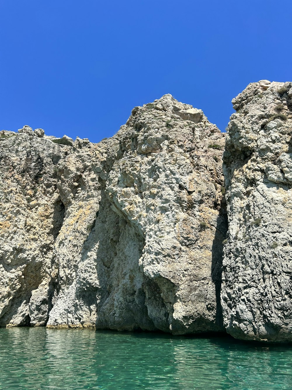 a large rock formation in the middle of a body of water