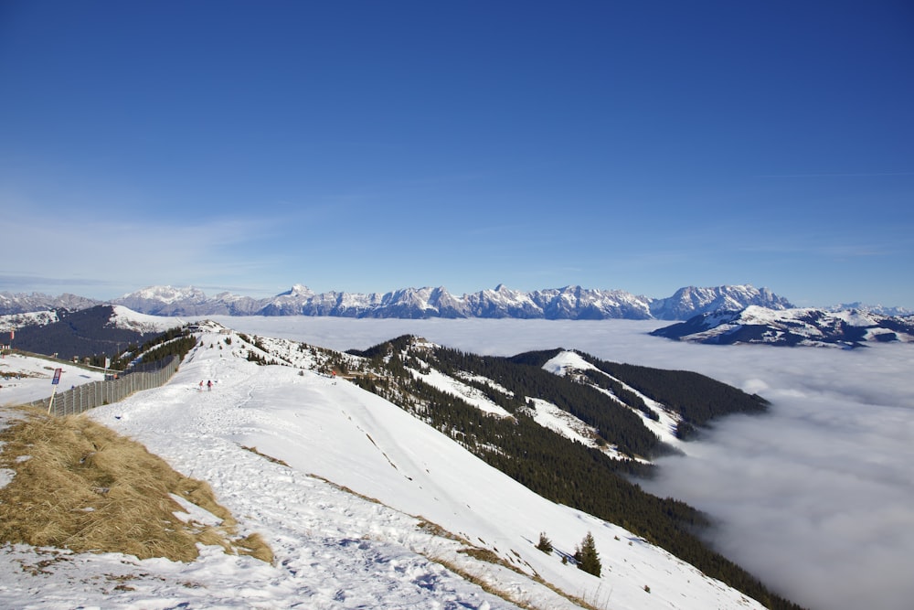 a view of a snowy mountain with a fence in the foreground