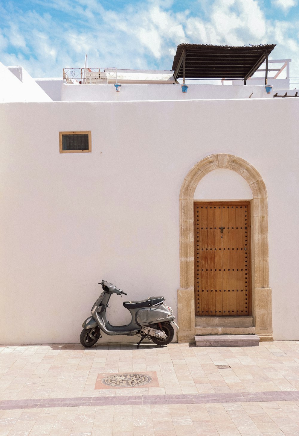 a scooter parked in front of a white building