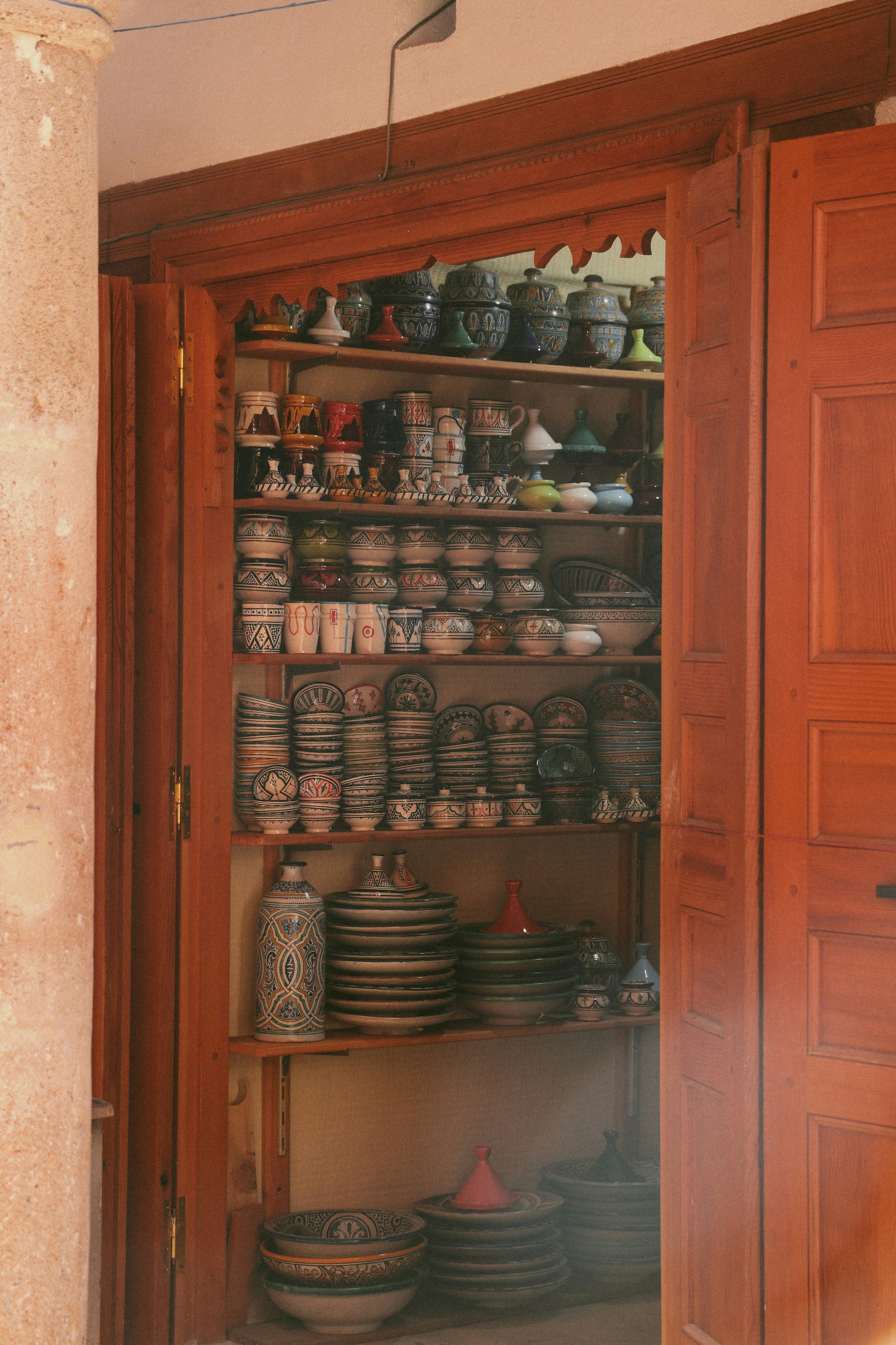 a wooden cabinet filled with lots of plates and bowls