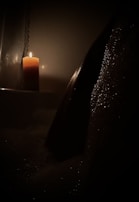 A candle lit in a dimly lit room for ambiance.