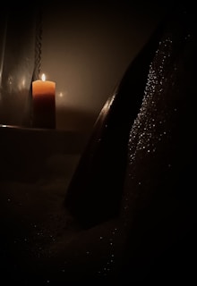 A candle lit in a dimly lit room for ambiance.