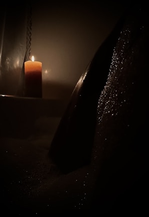 Soft candlelight flickering beside a meditation cushion in a cozy room.