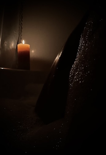 A serene setting with a candle lit, casting a gentle glow in a cozy room.