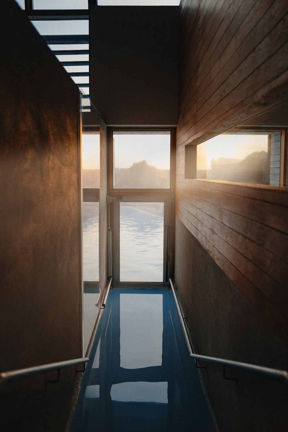 une chambre avec un plancher de verre et une vue sur l’eau