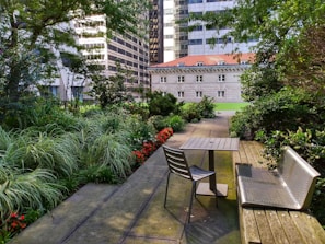 Small garden space with potted plants and rustic wooden bench