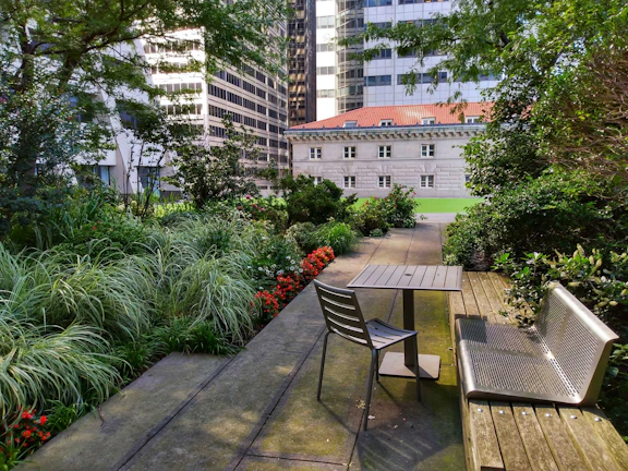 A small garden patio designed with smart space use, blending greenery and seating harmoniously.