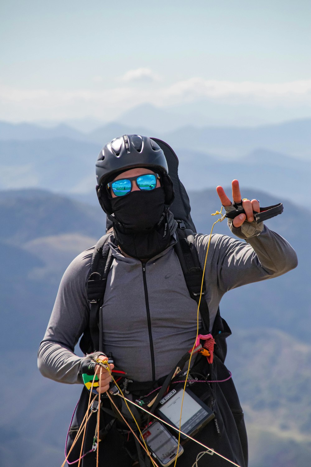 a man in a helmet and goggles holds up a pair of skis