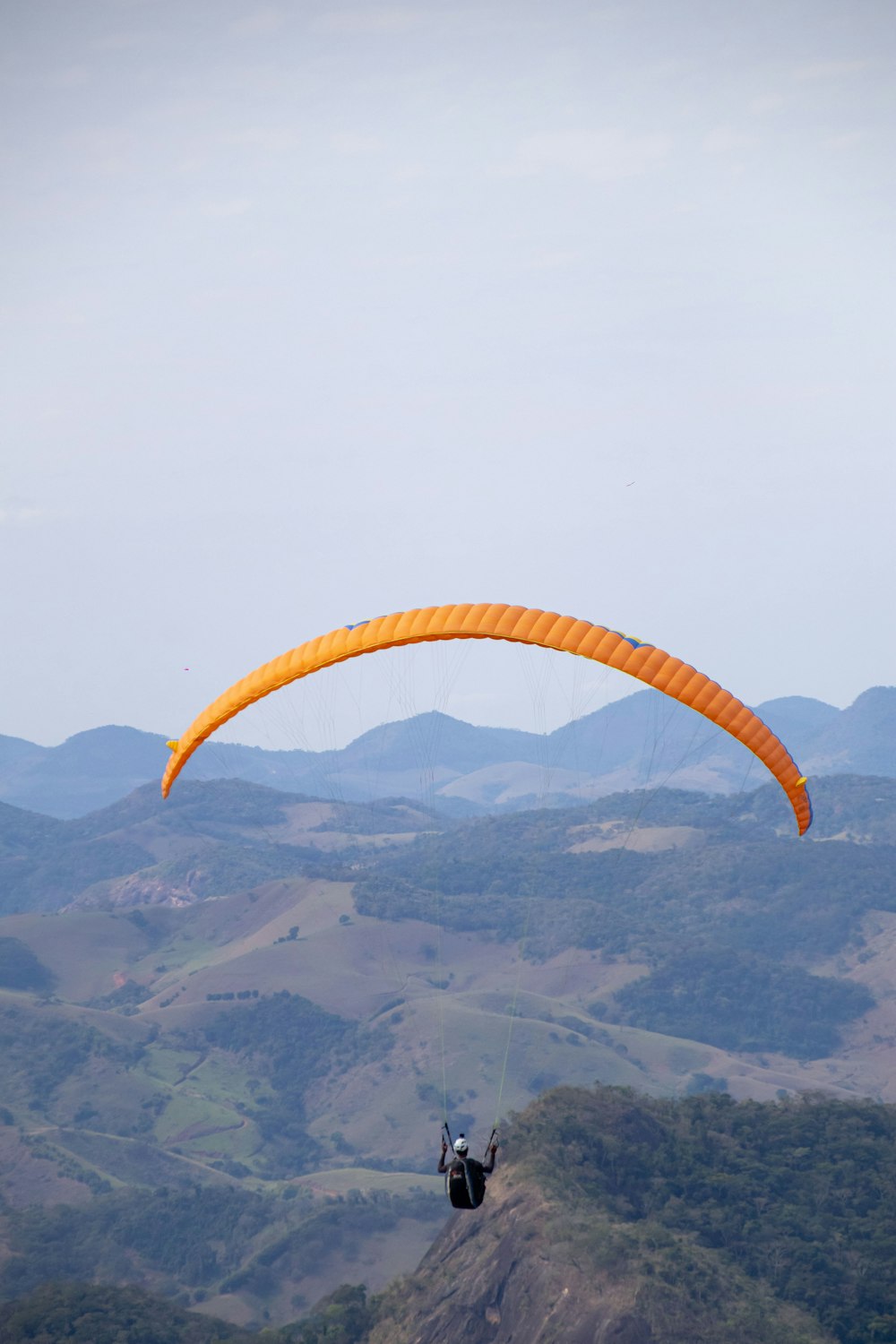 a person is parasailing over a mountain range