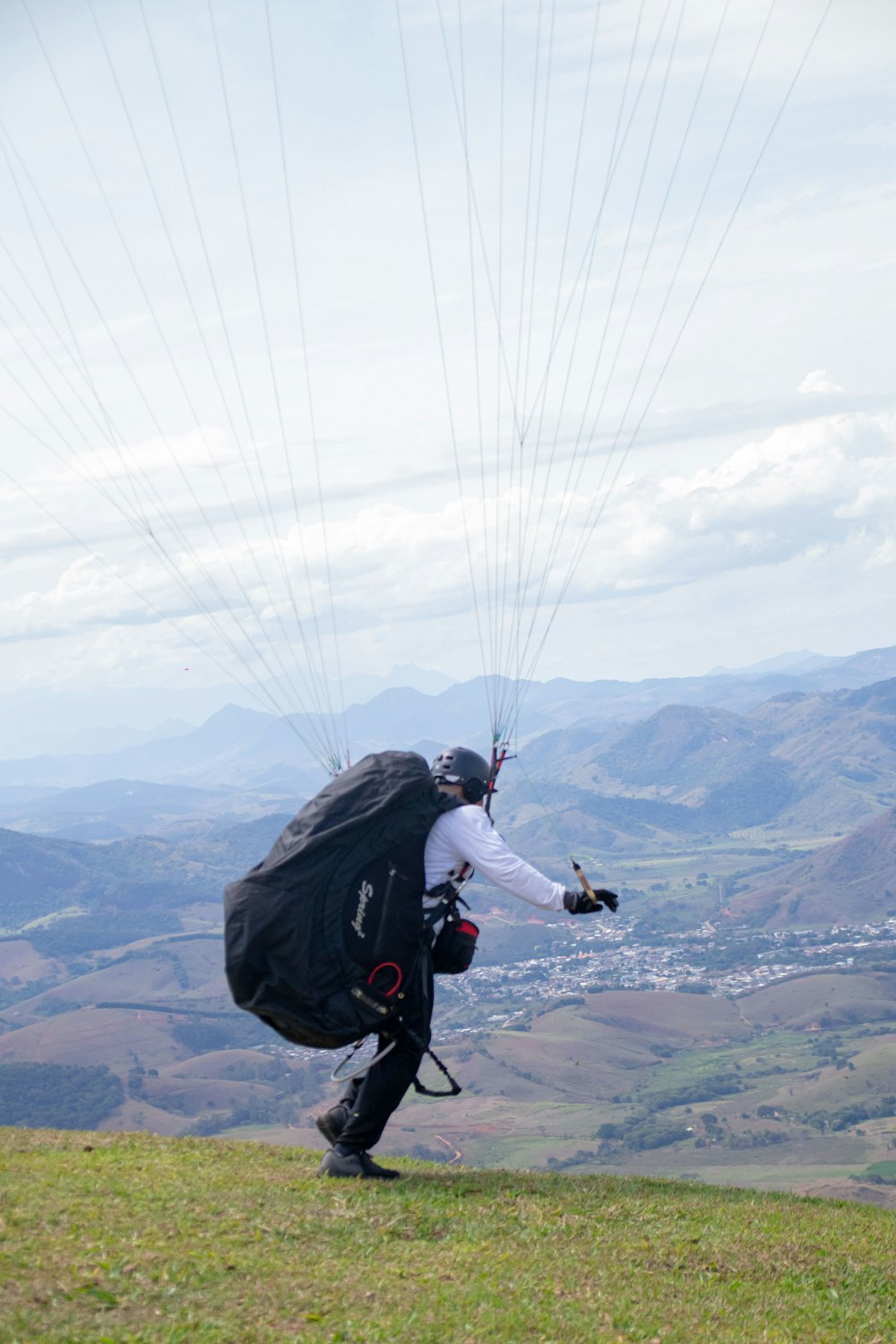 a person with a backpack and parachute on a hill