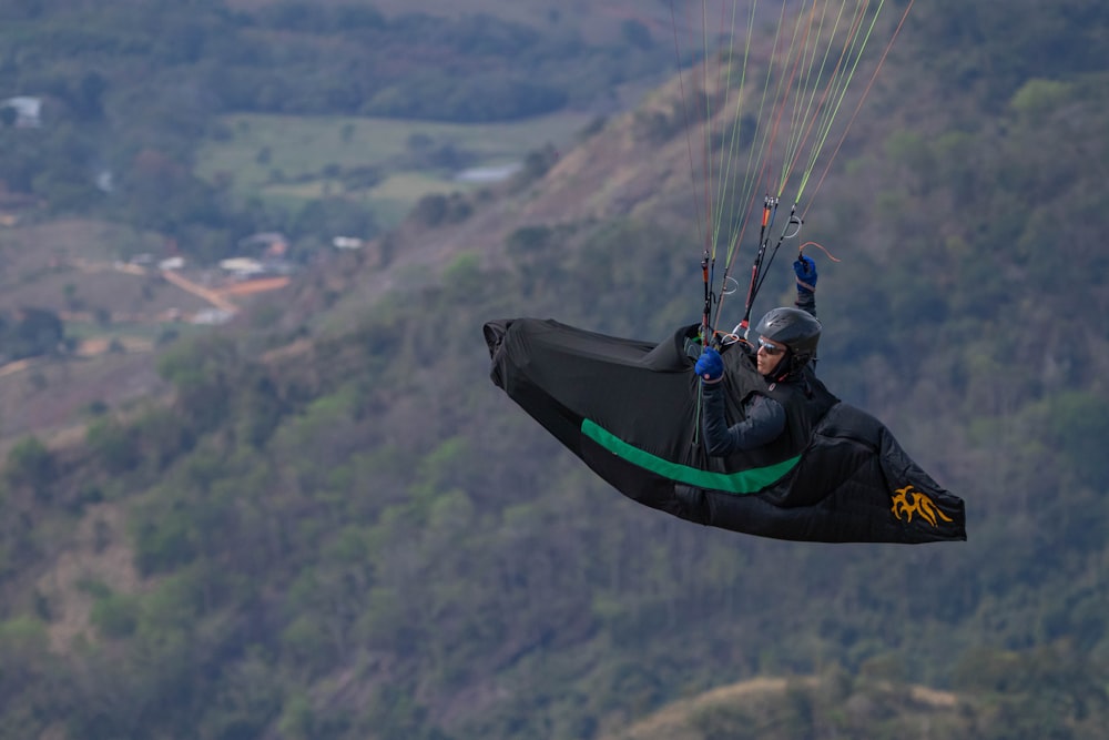 a person is parasailing in the air over a mountain