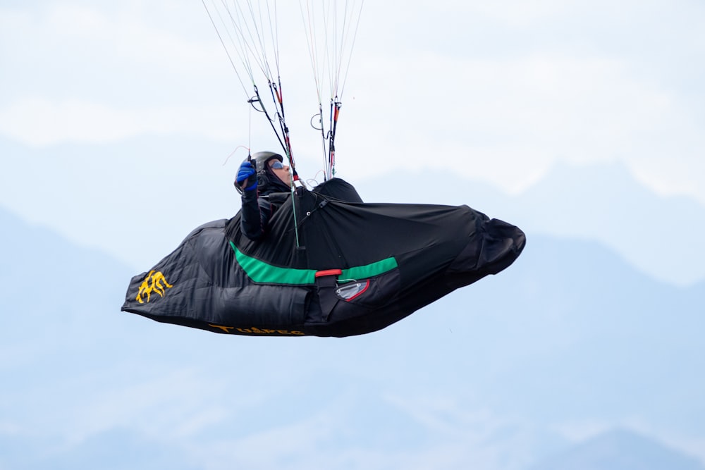 a man flying through the air while riding a kite