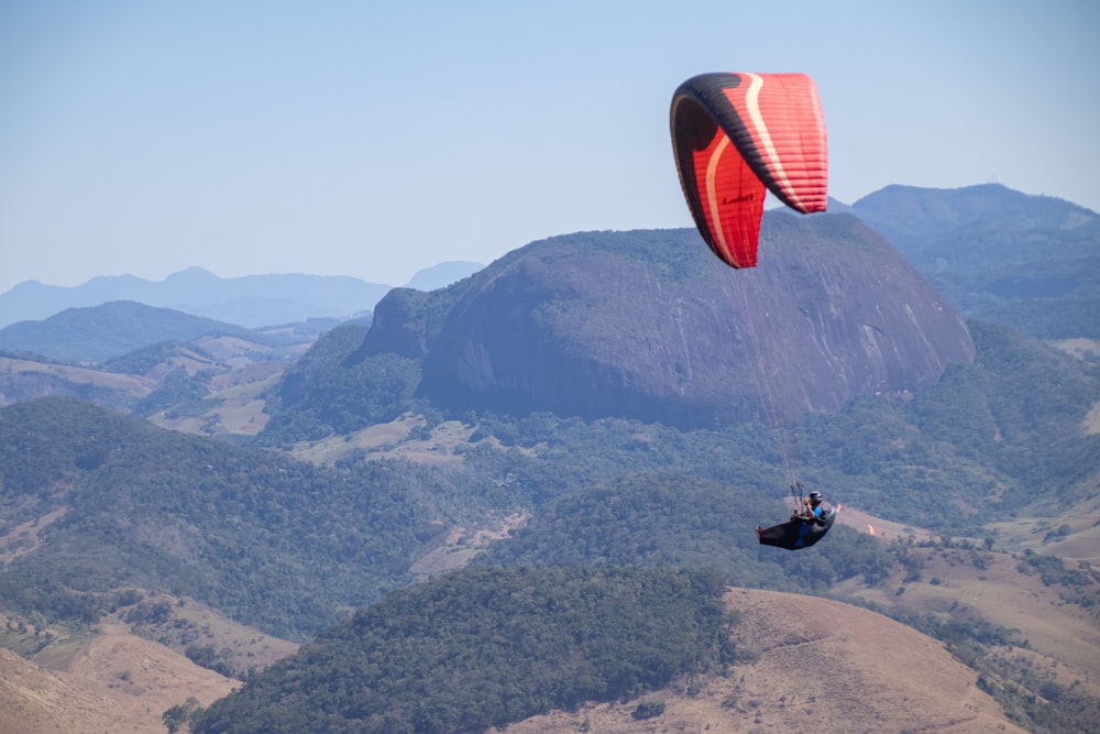 a person is parasailing over a mountain range