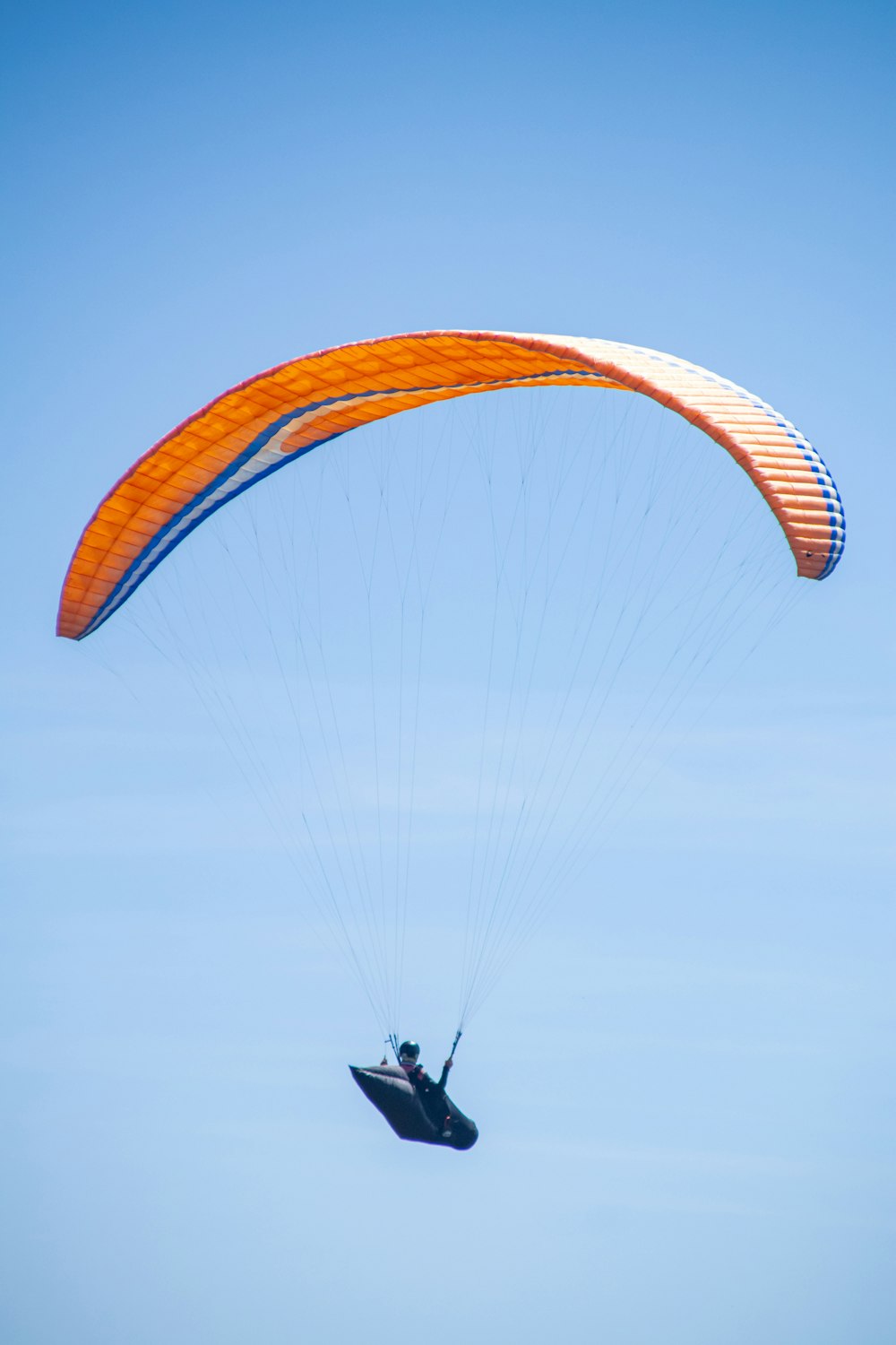 a person is parasailing in the blue sky