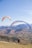 two people are paragliding over a mountain range