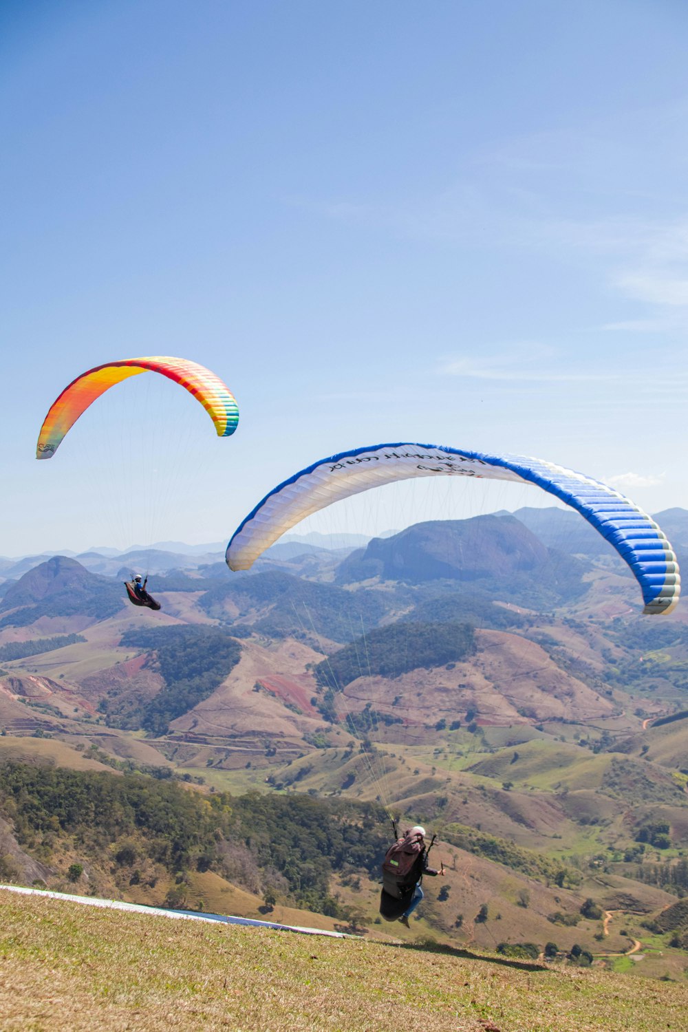 two people are paragliding over a mountain range