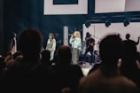 An artist performing live on stage with an audience.