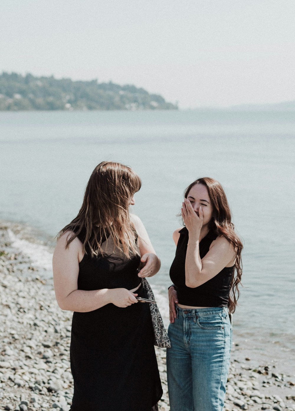 a couple of women standing on top of a beach