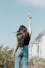 a woman standing in front of a house with her arms in the air