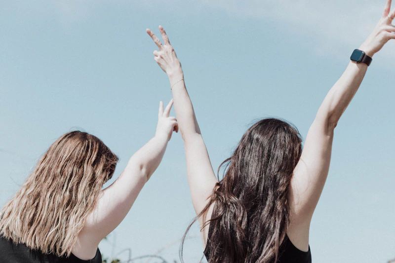 deux femmes tendant les mains pour attraper un frisbee