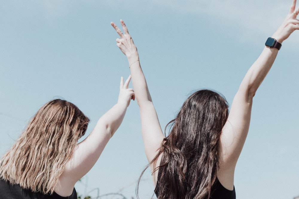 two women reaching up to catch a frisbee