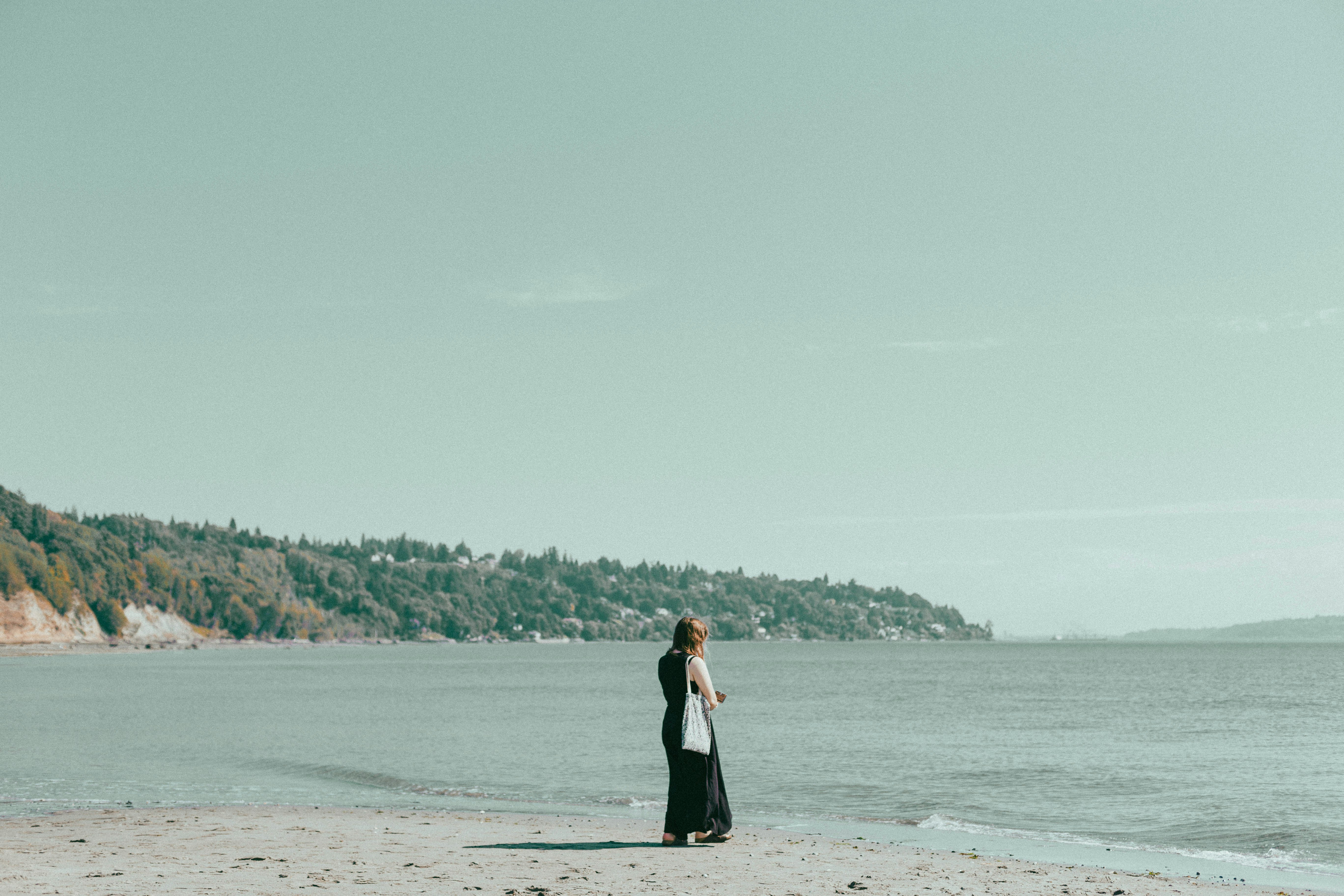 a woman standing on a beach next to the ocean