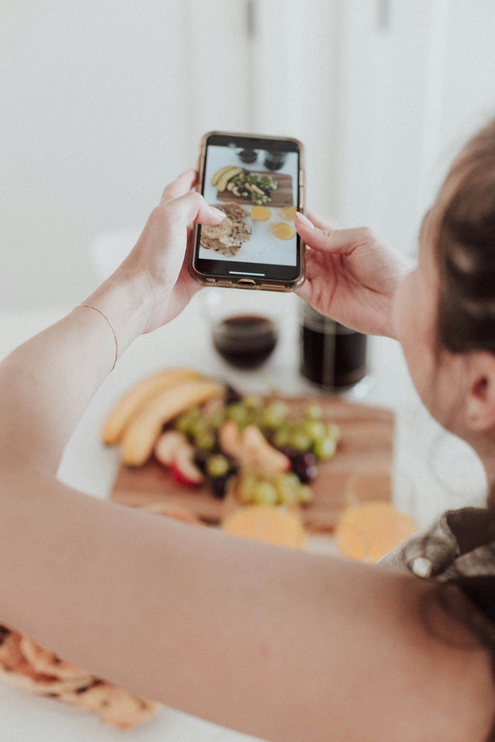 a woman taking a picture of food on her phone