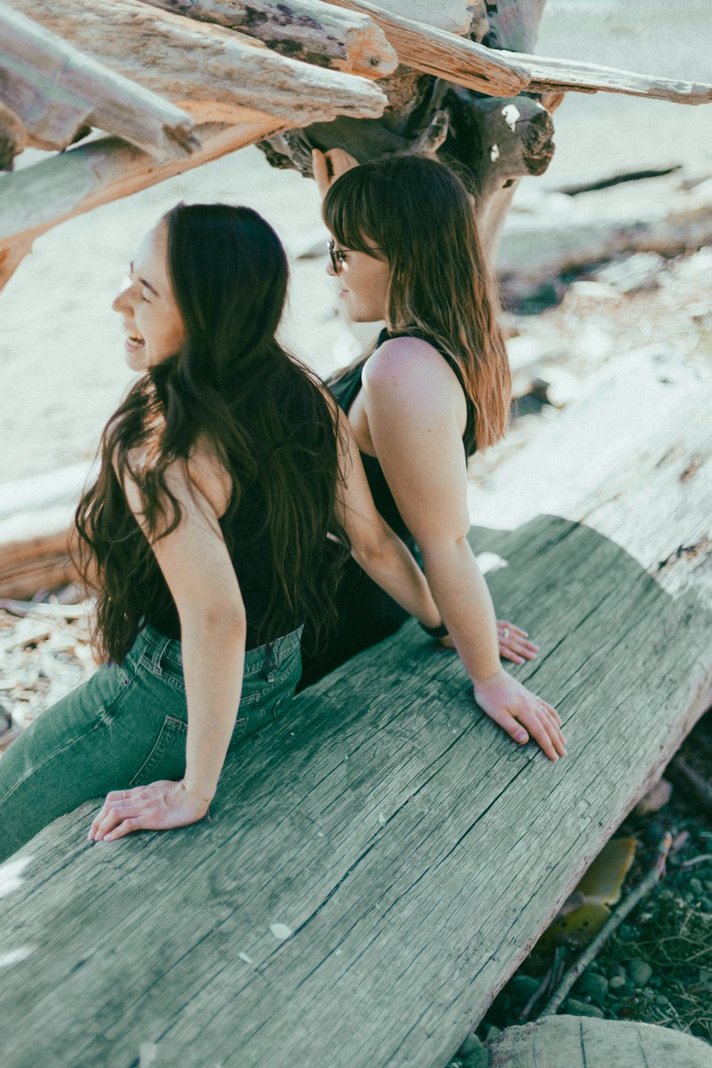 two young women sitting on a wooden bench