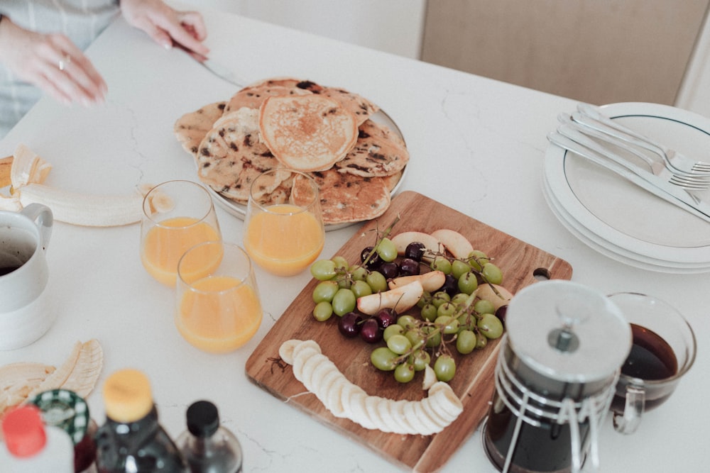 a white table topped with plates of food and drinks