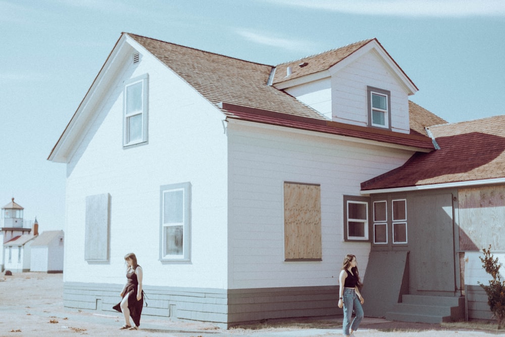 a couple of people standing in front of a house
