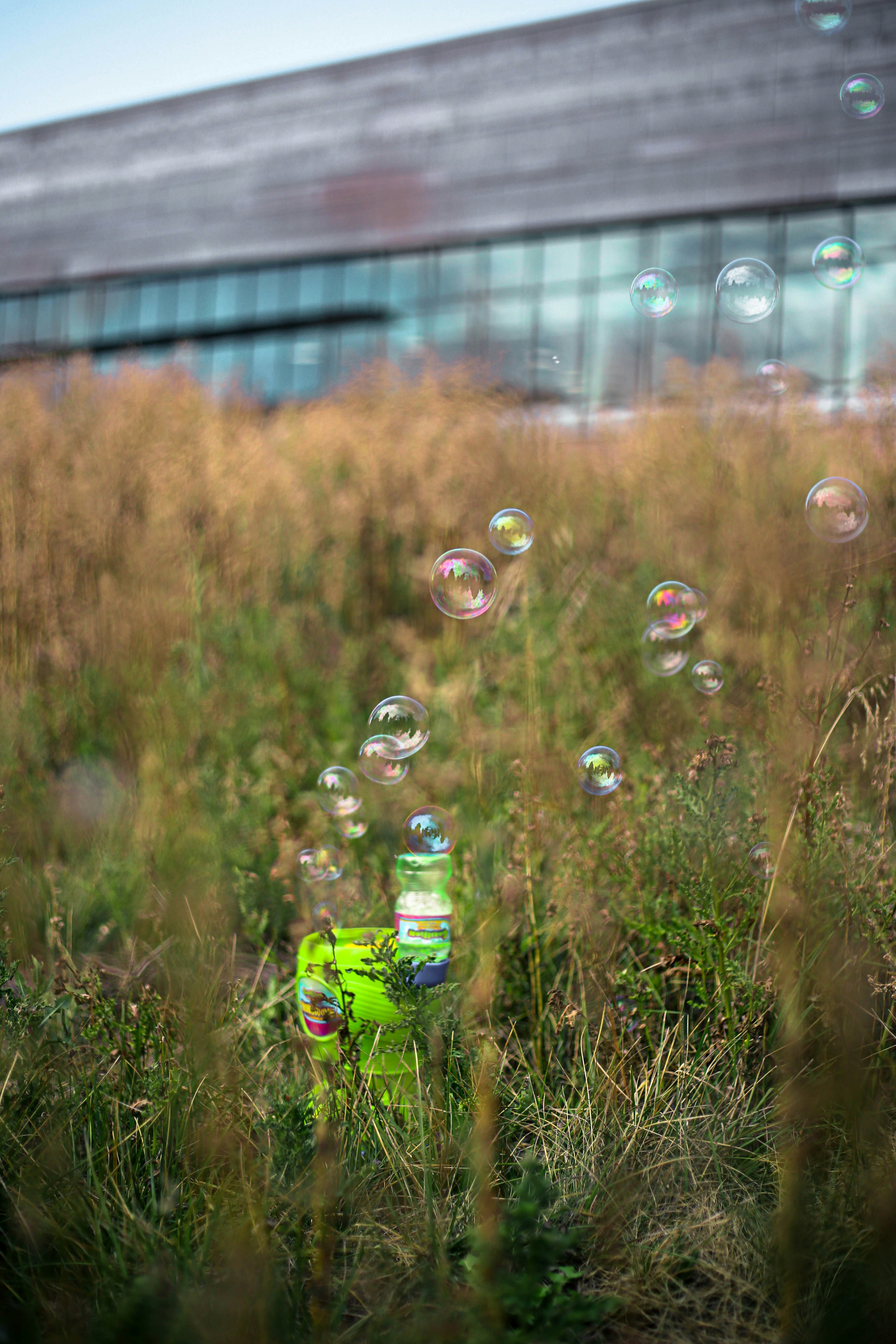 a green fire hydrant surrounded by bubbles in a field