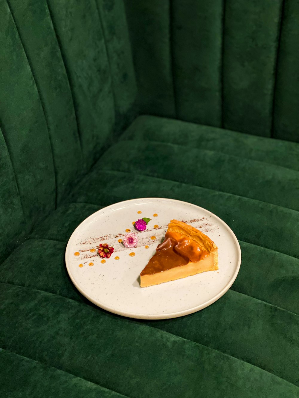 a piece of pie on a plate on a green couch