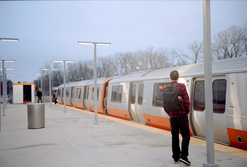Ein Mann, der auf einem Bahnsteig neben einem Zug steht
