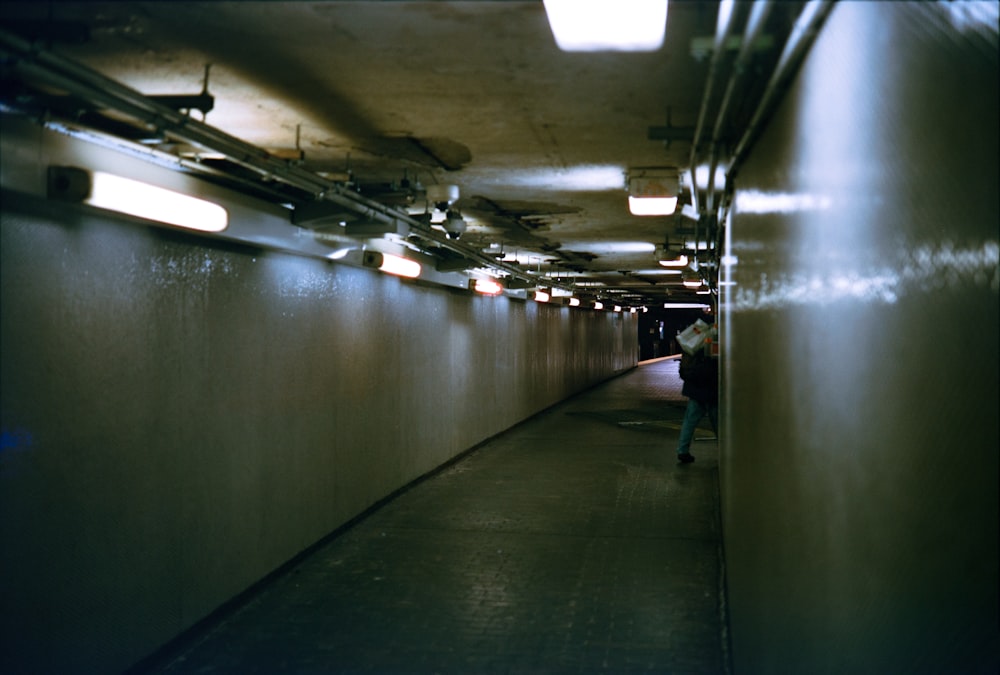 a person walking down a long hallway in a building