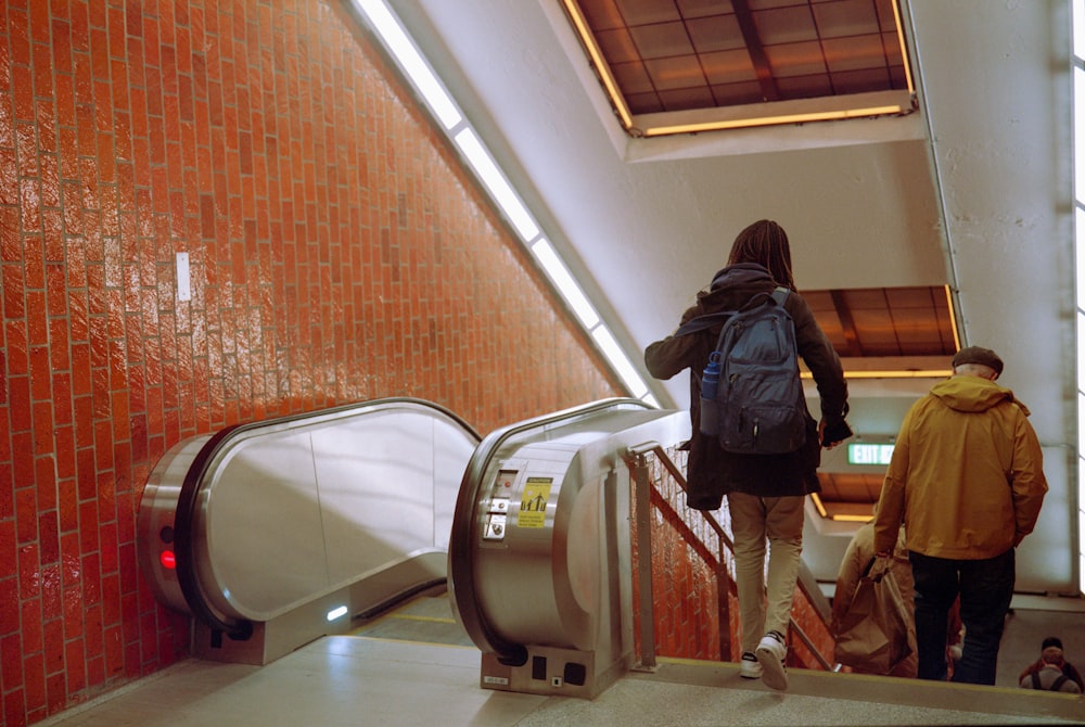 a couple of people that are walking up an escalator