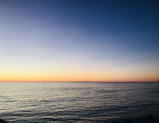 a body of water with a sky in the background