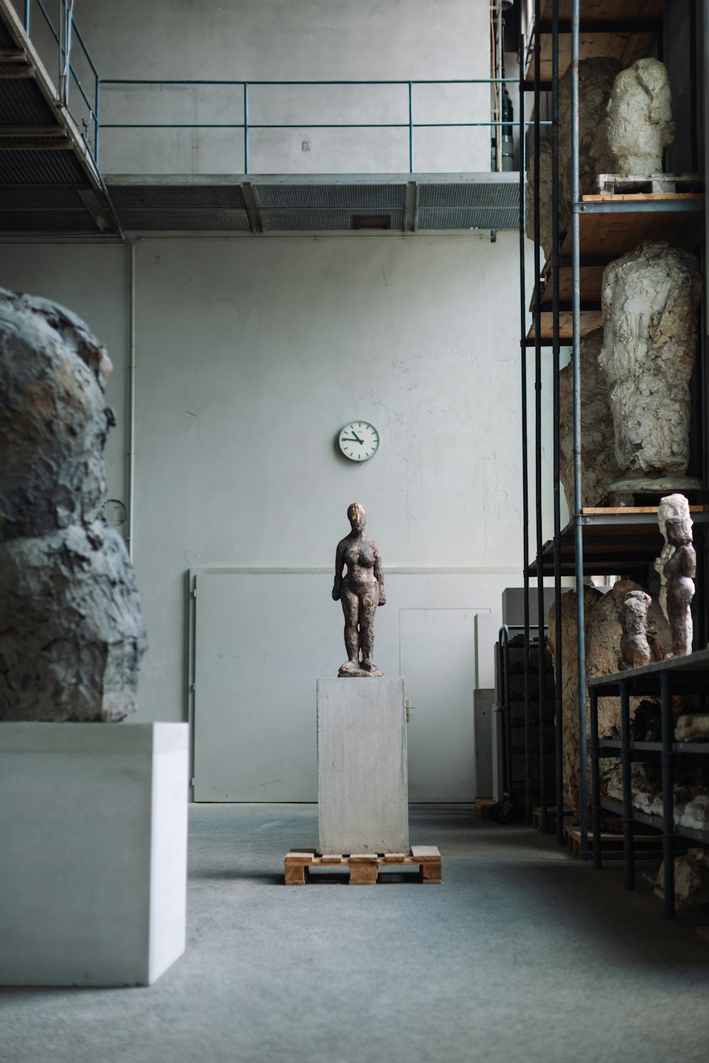 a statue of a man in a room with shelves