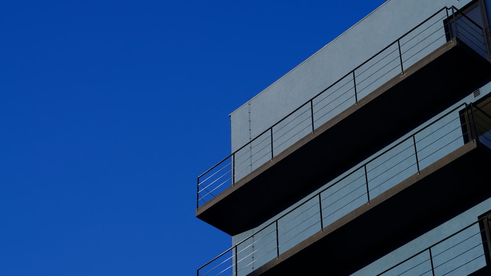 a tall building with balconies against a blue sky