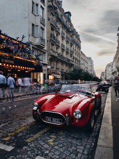 A cozy urban street scene in Paris with a small, colorful city car parked by a lively café.