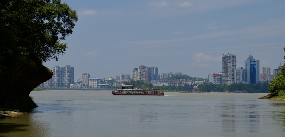 a boat traveling down a river with a city in the background