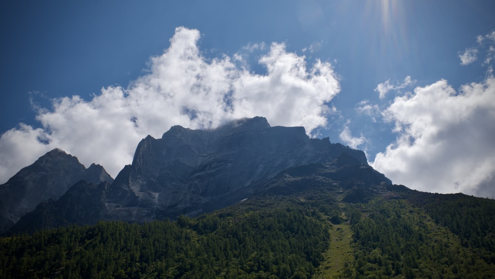 a very tall mountain with some clouds in the sky