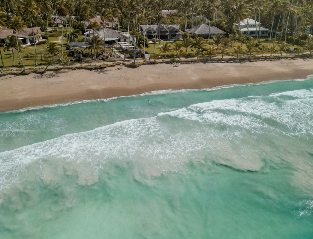 an aerial view of a beach with houses in the background