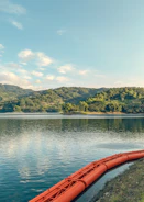 a red canoe sitting on the edge of a lake