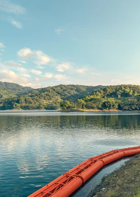 a red canoe sitting on the edge of a lake